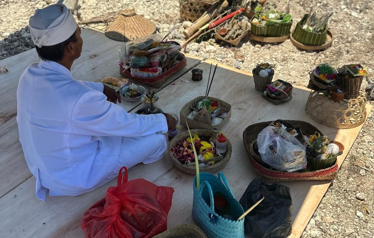Sveštenik priprema prinose za obred Ngeruwak na gradilištu Ananta Villas Nusa Dua