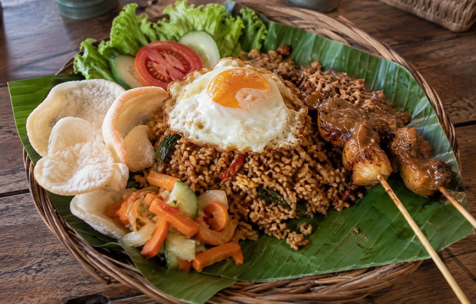 Nasi goreng s kuřecím saté, sázeným vejcem a krevetovými chipsy